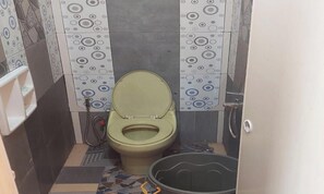 Pieni kylpyhuone, jossa on wc, suihku ja pesuallas.