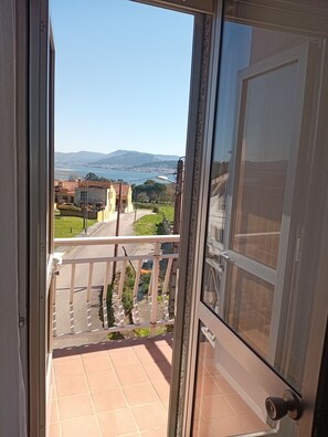 A balcony with a view of a coastal town, a clear sky, and distant mountains. - Dormitory between Trega and Minho A GUARDA (A Guarda)