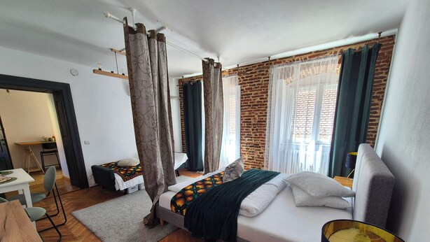 Une chambre d’hôtel avec un lit, un bureau, une chaise et une lampe.