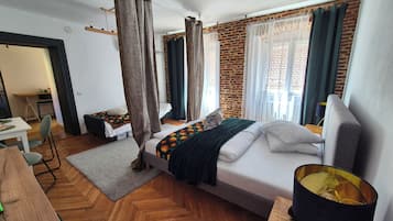 Une chambre d’hôtel avec un lit, un bureau, une chaise et une lampe.