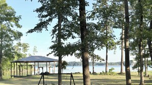 A gazebo with a metal roof, a swing set, and a lake in the background. - Pendleton Paradise Waterfront Cabin on Lanan Bay (Zwolle)