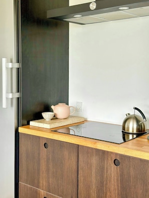 A kitchen with a modern design, featuring a wooden countertop, a stainless steel kettle, and a ceramic teapot. - Wake up to views of Kattegat and Samsø (Norsminde)