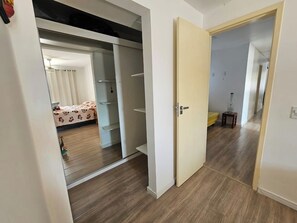 Une porte ouverte donnant sur une pièce où se trouvent un lit et une armoire.