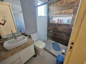 Une salle de bain avec un lavabo, des toilettes et une douche.
