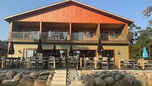 A two-story building with outdoor seating and a stone pathway leading to the entrance. - Cass Lake Lodge (Cass Lake)