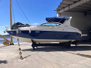 Un bateau nommé « Excel » était amarré dans une marina dont le sol était en béton, et un ciel dégagé se dessinait à l’horizon.
