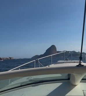 L'intérieur d'un bateau, avec vue sur la mer et sur des reliefs terrestres lointains.