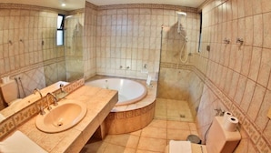 A bathroom with a sink, mirror, shower, and toilet.
