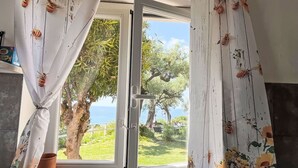 Une pièce dotée d’une porte-fenêtre coulissante donnant sur un jardin avec vue sur la mer.