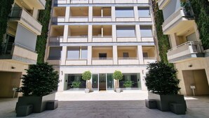 A multi-story building with a central entrance, balconies, and potted plants. - Domus Aventinae relax & fit (Roma)