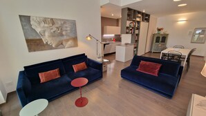 A modern living room with two blue sofas, a red table, and a painting on the wall. - Domus Aventinae relax & fit (Roma)