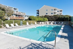 Ein Swimmingpool mit Liegestühlen und einem Gebäude im Hintergrund.