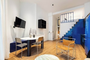 Ein modernes Interieur mit Essbereich, Treppe und an der Wand befestigtem Fernseher.
