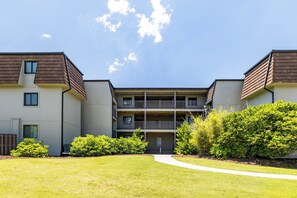 A two-story apartment building with a central courtyard, balconies, and a well-maintained lawn. - Southwinds A9 - 2 Bedrooms, 1.5 Baths, Oceanfront Condo (Atlantic Beach)