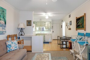 A living room with a couch, chairs, a dining table, and a kitchen in the background. - Southwinds A9 - 2 Bedrooms, 1.5 Baths, Oceanfront Condo (Atlantic Beach)