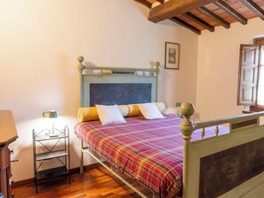 A bedroom with a bed, a bedside table, a lamp, a picture on the wall, and a window. - Lovely apartment for 6 guests with A/C, WIFI, pool, TV, patio and pets allowed (Panicale)
