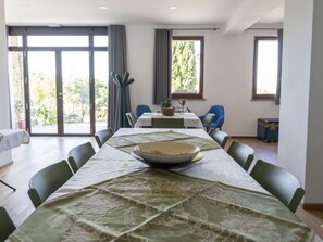 A dining area with a table set for four, chairs, a plant, and a window with curtains. - Lovely apartment for 4 guests with A/C, WIFI, pool, TV, patio and pets allowed (Panicale)