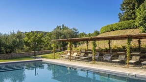 A swimming pool with lounge chairs and a pergola. - Nice apartment for 4 people with WIFI, pool, A/C, TV, patio and pets allowed (Panicale)