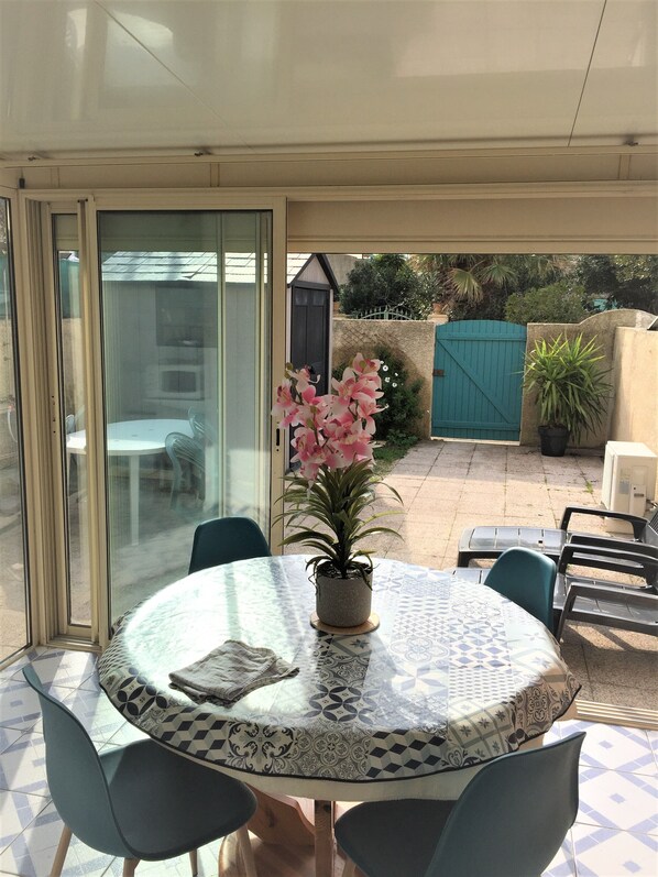 A round table with chairs, a potted plant, and a patterned tablecloth.