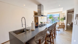 Une cuisine moderne dotée d’un grand îlot central, d’une cuisinière intégrée et offrant une vue sur la ville.