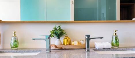 Un baño con dos lavamanos, un espejo y una planta en la encimera.