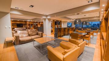 A modern living area with a leather sofa, a glass coffee table, and a dining area with wooden furniture.