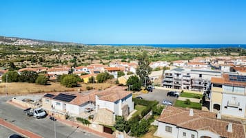Un quartier résidentiel avec des maisons, une rue et une vue dégagée sur la mer.