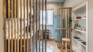 Eine Küche mit Holzlatten, einem blauen Kühlschrank und einem Hocker.