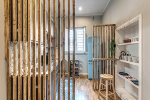 Una cucina con listelli di legno, un frigorifero blu e uno sgabello.