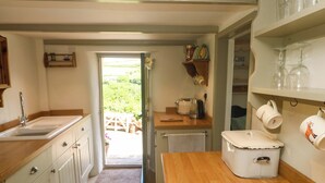Cocina con pileta, mostrador de madera y vista al exterior.