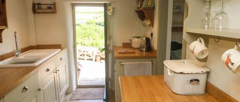 Cocina con pileta, mostrador de madera y vista al exterior.