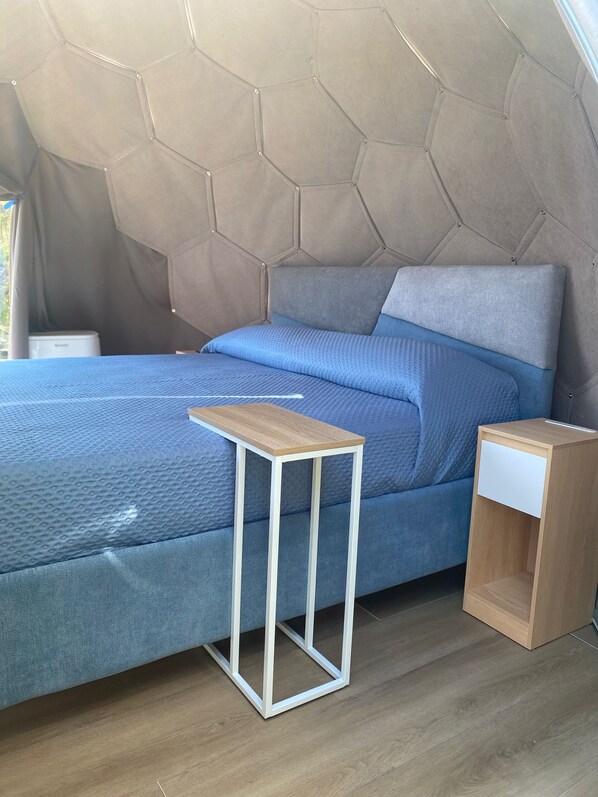 A bedroom with a bed, a bedside table, and a nightstand. - Vrbo Property (Marciano)