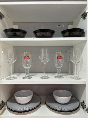 A shelf with wine glasses and bowls. - Lovely 1-bedroom with personal backyard in Sunrise (Sunrise)