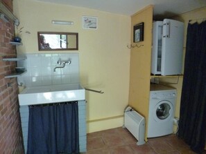 Une petite salle de bain comprenant un lavabo, un miroir, un porte-serviettes et un petit radiateur.