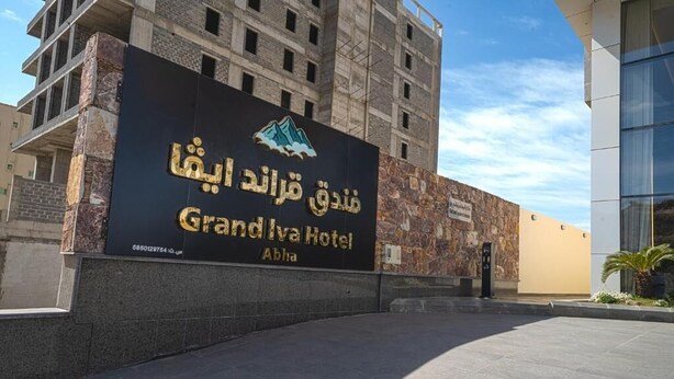 A hotel sign with Arabic text and a mountain logo. - Grand Iva Hotel Abha (Abha)