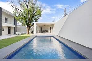 A modern building with a swimming pool, a tree, and a patio area. - Loft Moderno con 2 Queen Beds Zona Tec  loft 17 (Monterrey)