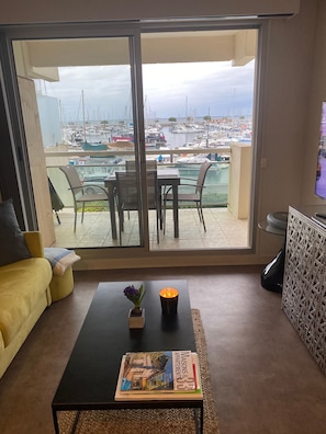 En stue med balkon med udsigt over en lystbådehavn.