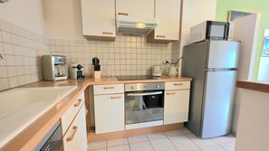 Eine kleine Küche mit Spüle, Toaster, Wasserkocher und Kühlschrank.
