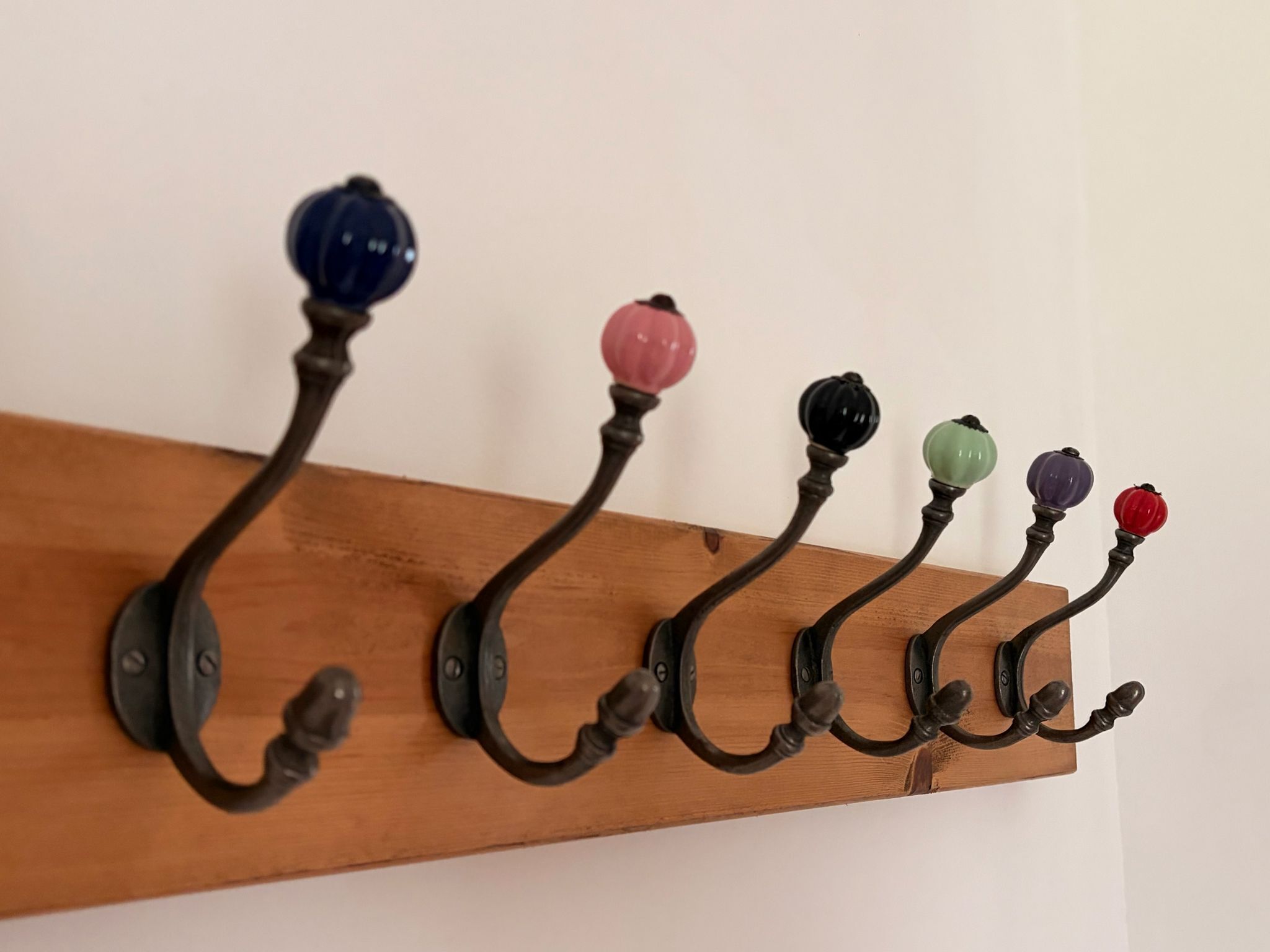Een houten wandrek met meerdere haken.