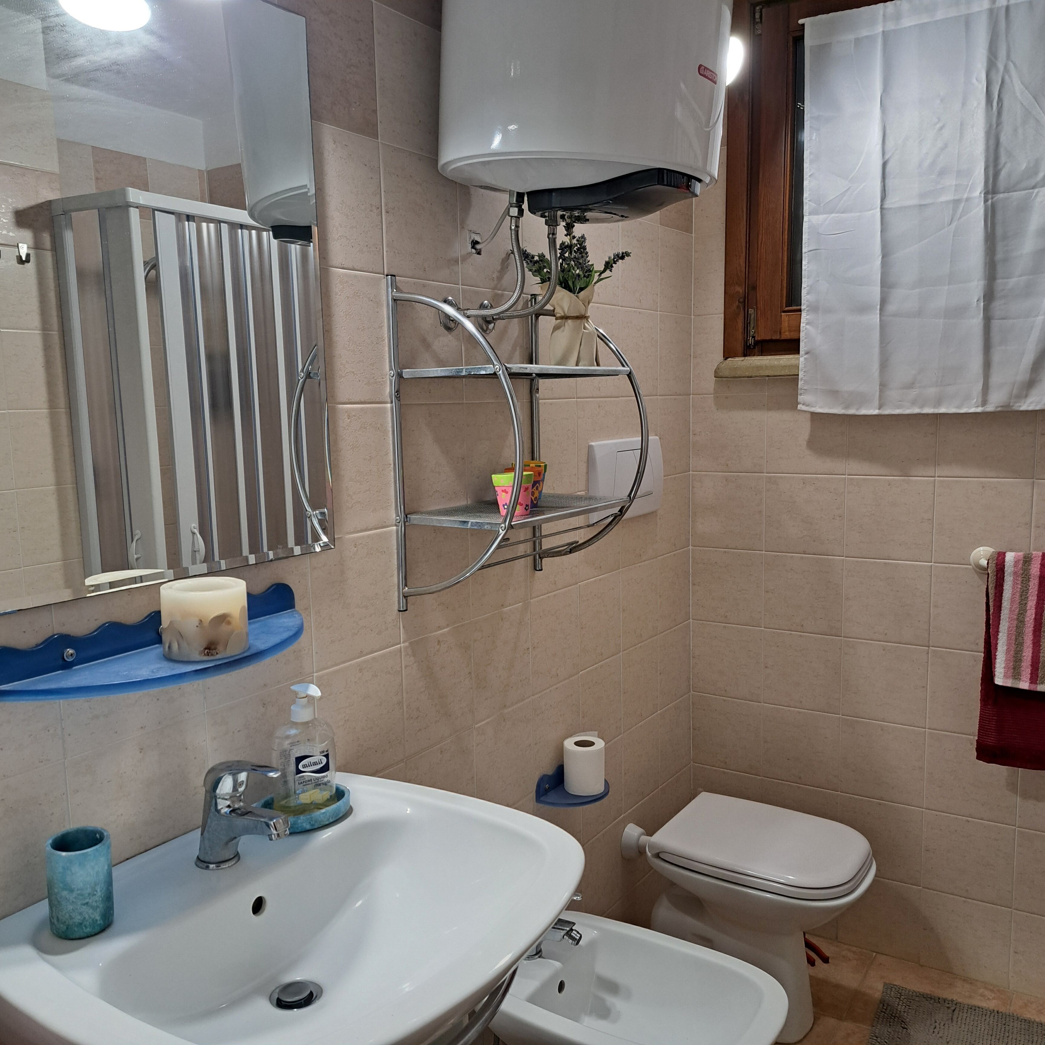 Une salle de bain avec un lavabo, des toilettes et une douche.