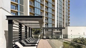 Ein modernes Gebäude mit Dachterrasse, ausgestattet mit Liegestühlen und einer überdachten Sitzgelegenheit.