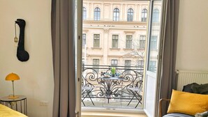 A hotel room with a balcony, a bed, a chair, and a guitar on the wall. - Exceptional design loft directly on Mariahilfer Strasse i (Vienna)