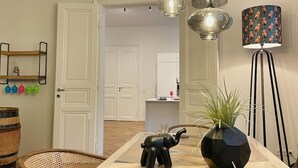 A dining area with a wooden table, a decorative elephant figurine, a potted plant, and a lamp with a patterned shade. - Exceptional design loft directly on Mariahilfer Strasse i (Vienna)