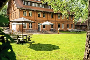 A brick building with outdoor seating and a grassy lawn.
