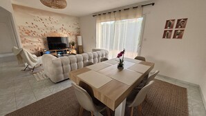 Un salon moderne avec un canapé, une table à manger et un téléviseur.