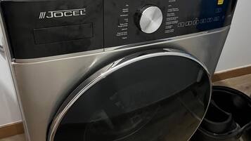 A front view of a front-loading washing machine with a control panel, a digital display, and a stainless steel door.