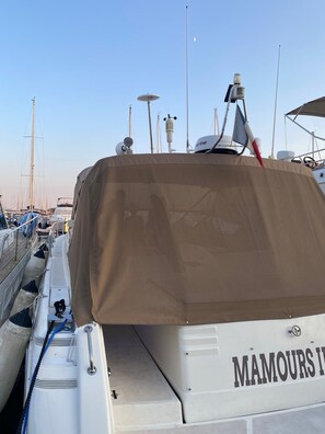 Un bateau couvert avec lâinscription « MAMOURS » sur le cĂŽtĂ©, un treuil et un mĂąt.