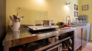 A modern kitchen with stainless steel appliances, a sink, and a countertop with utensils. - Charming Venetian  Retreat-3 Bedrooms, Dorsoduro (Venezia)
