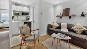 Una sala moderna con un sofá, una mesita y una silla.