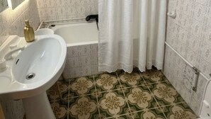 A bathroom with a sink, bathtub, toilet, and patterned floor tiles. - Charming Holiday House in Almazora (Almassora)